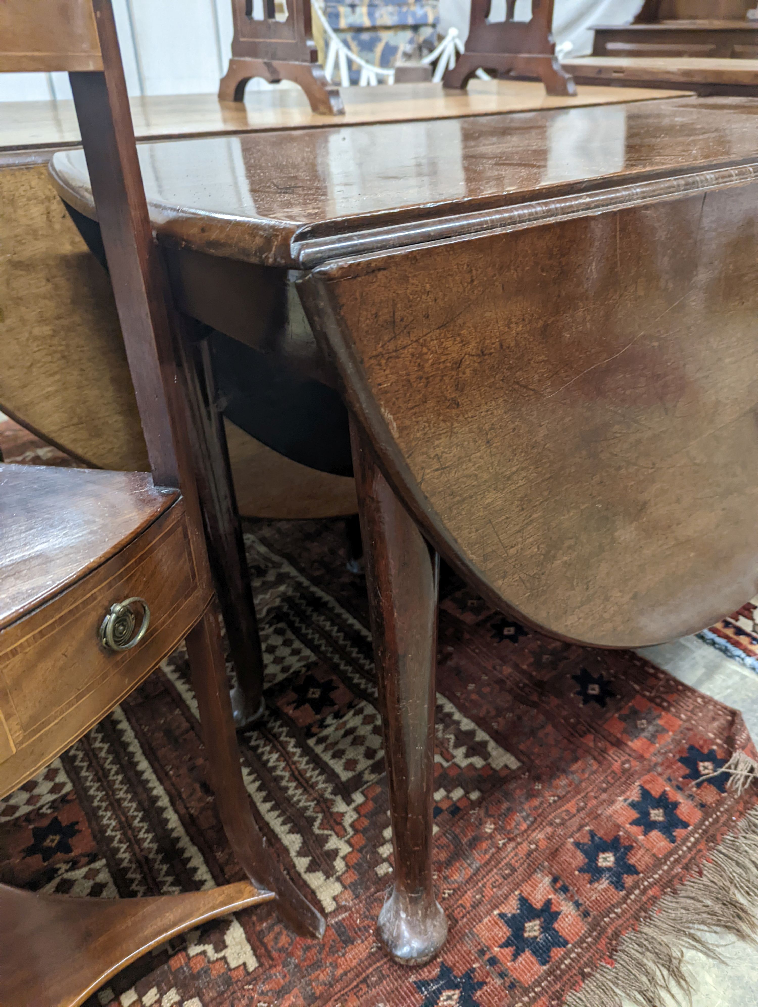 A George III oval mahogany drop leaf pad foot dining table, width 108cm, length 134cm extended, height 70cm